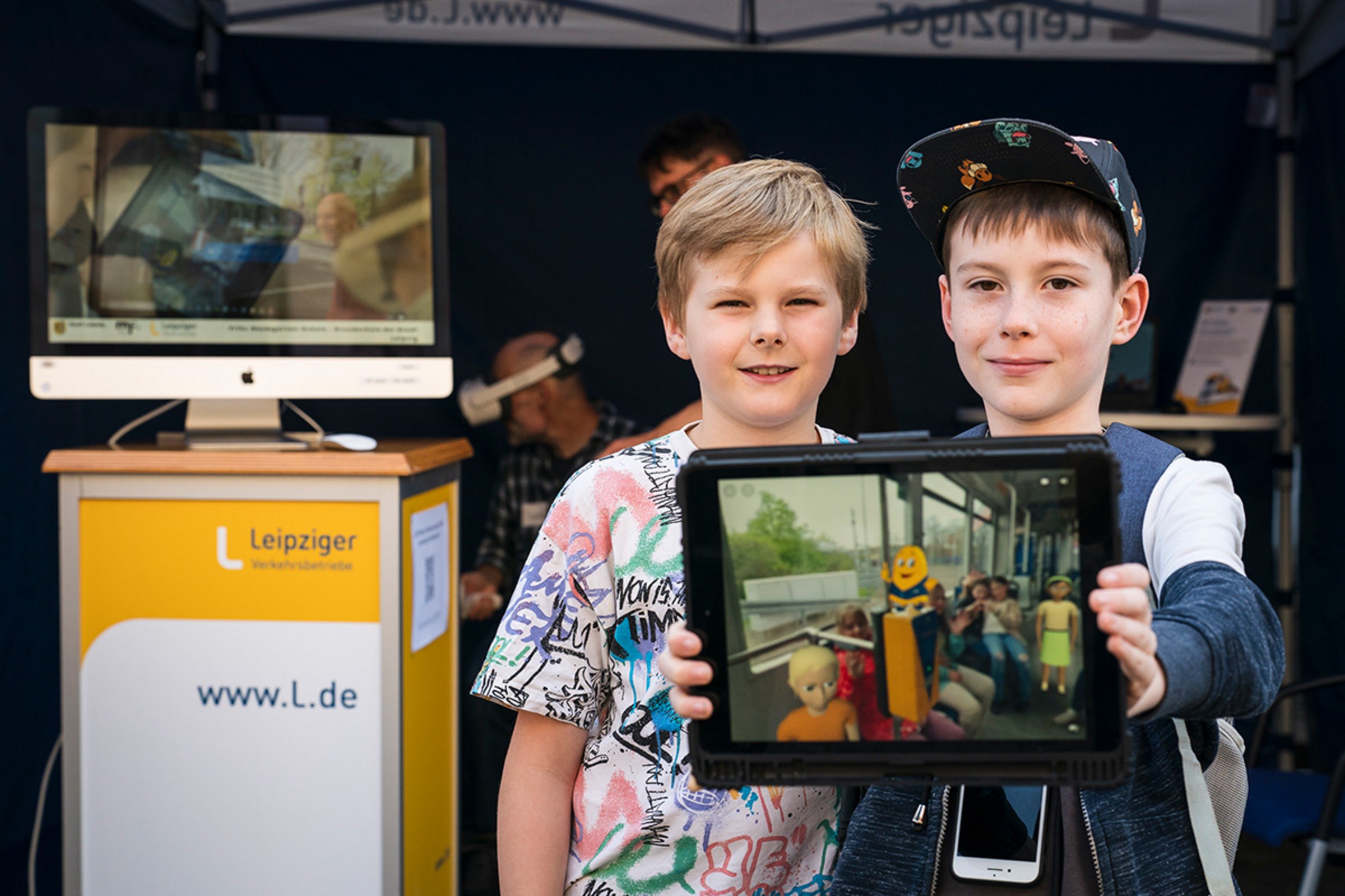 Zwei Kinder mit Tablet vor dem Aktionsstand