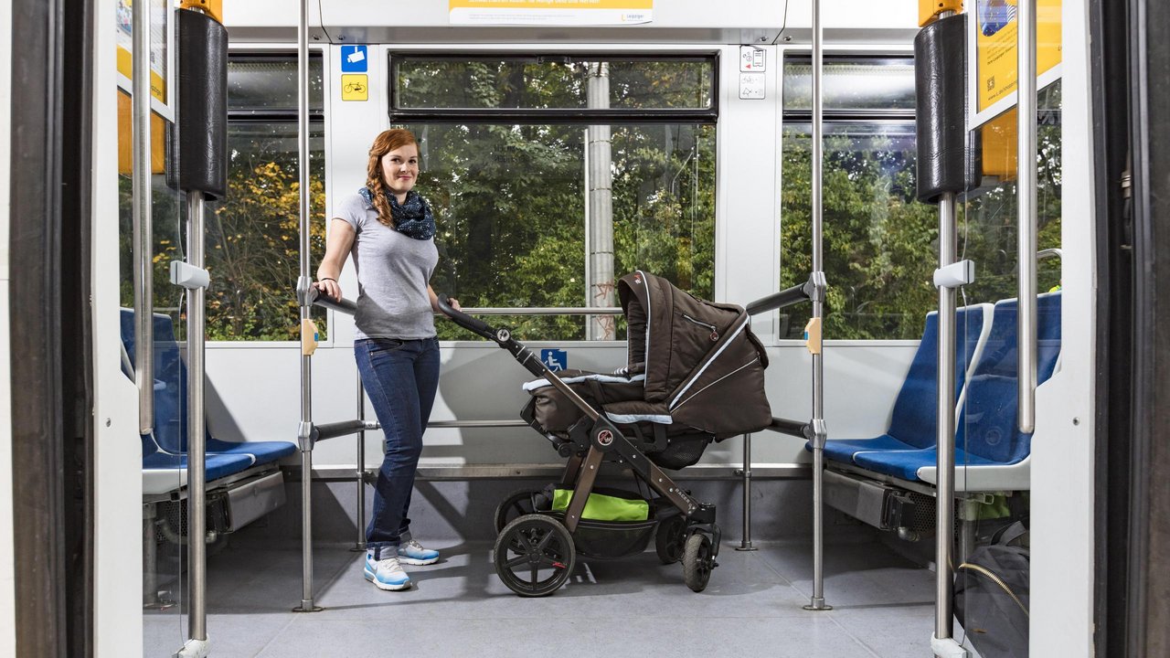 Eine Mutter mit ihrem Kinderwagen in der Straßenbahn